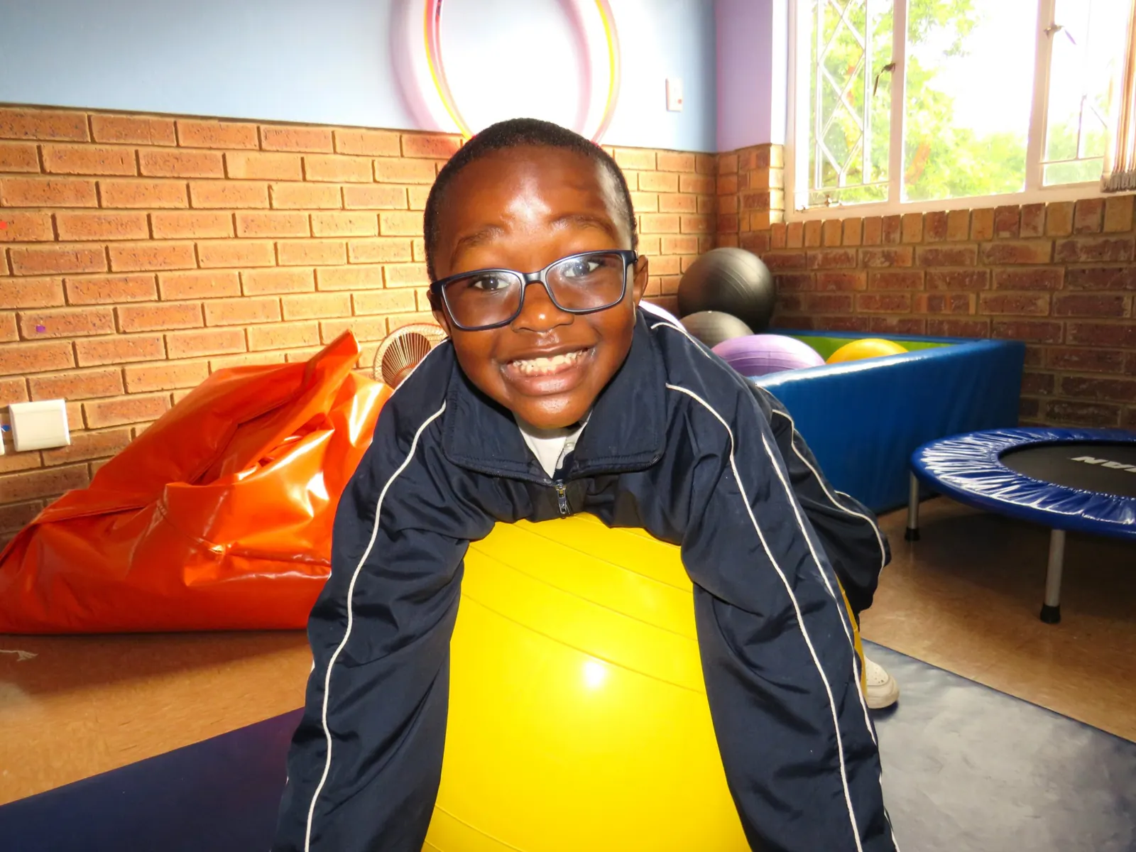 A pupil on a yellow therapy ball